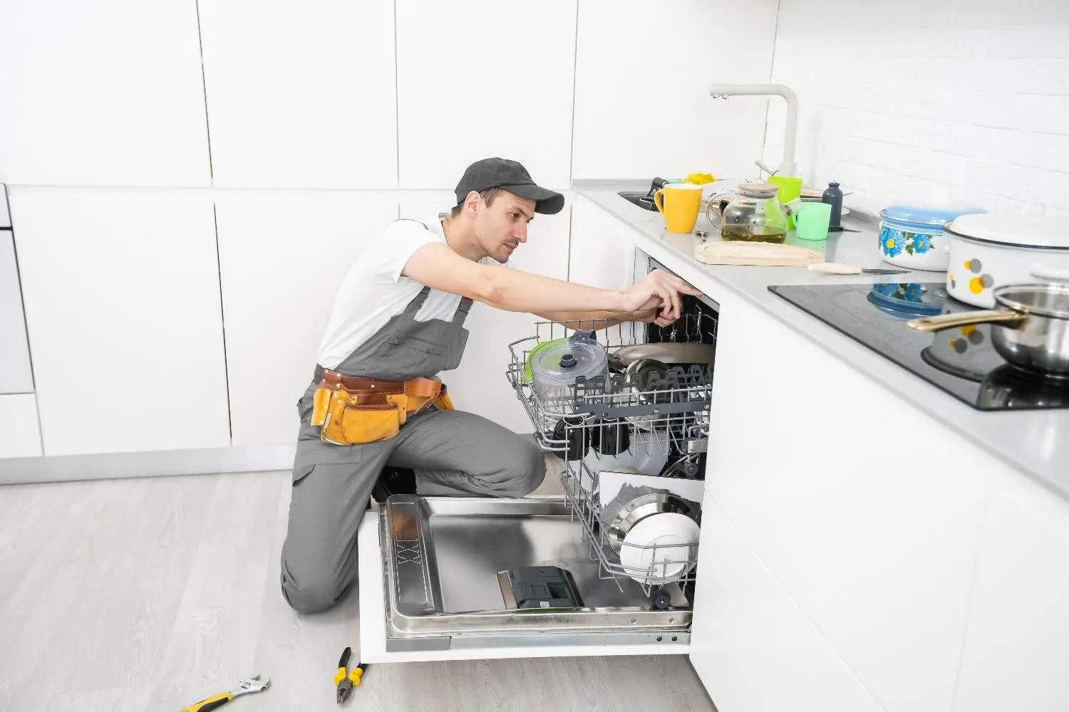 Technician checking a dishwasher in a bright kitchen